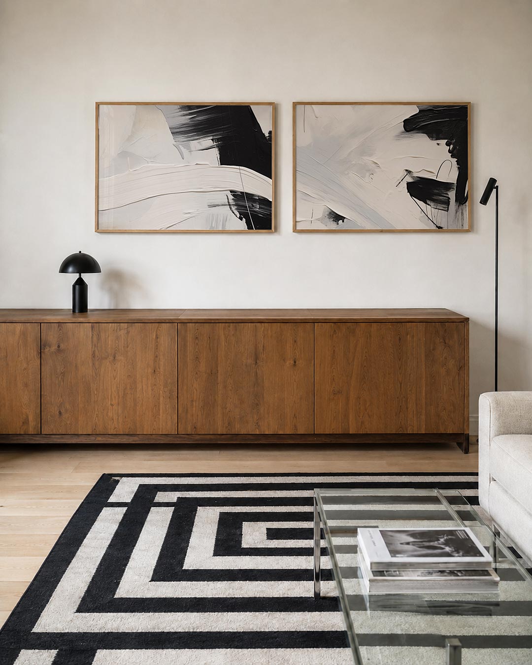 Twee liggende posters met een krachtig spel van dikke, vloeiende lijnen in zwart, wit en grijs, aan de muur in een interieur