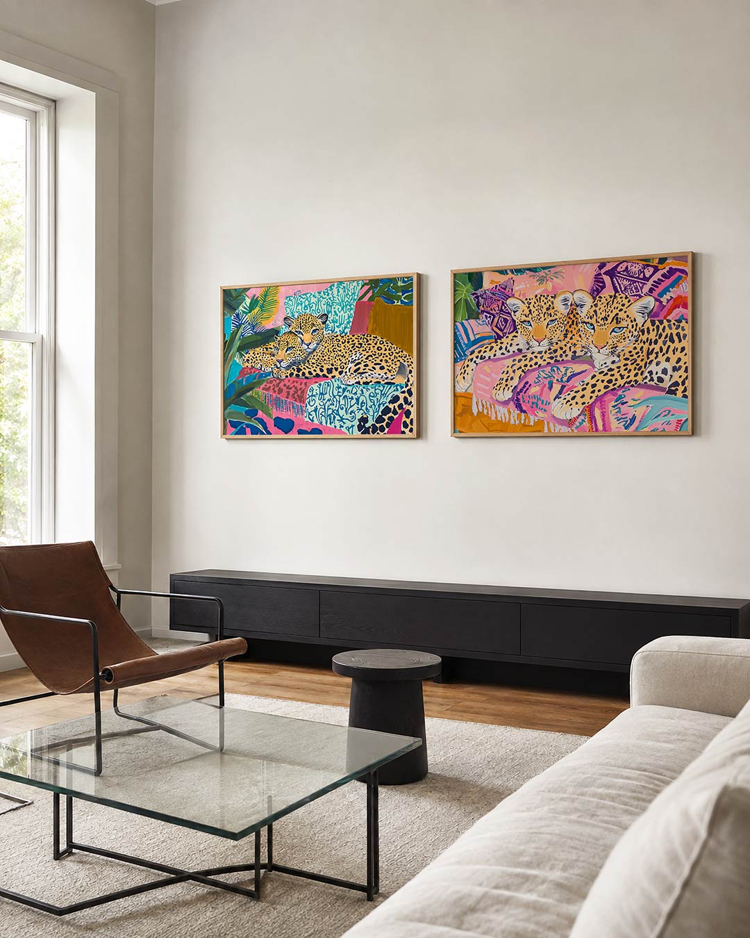 Interieurbeeld met twee liggende posters: twee luipaarden tussen bladeren en kleurrijke vormen