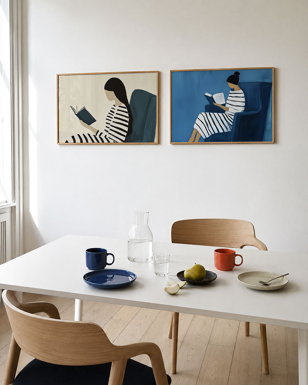 Twee liggende posters met een vrouw met lang donker haar met een boek, aan de muur in een interieur