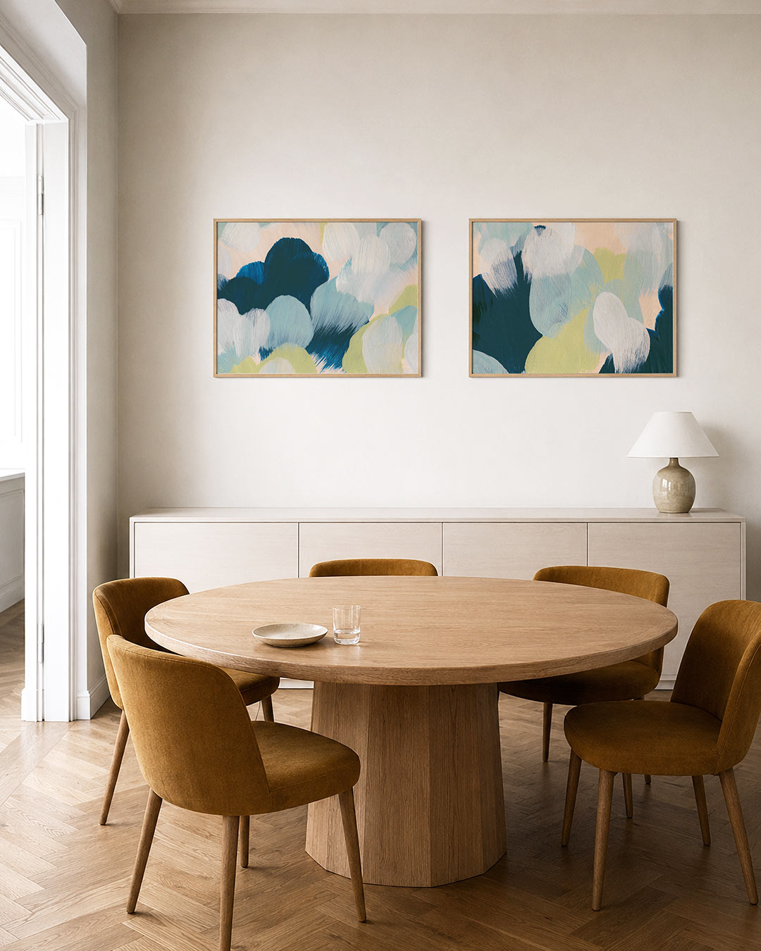 Twee liggende posters met zachte, ronde vormen in blauw, groen en wit, aan de muur in een interieur