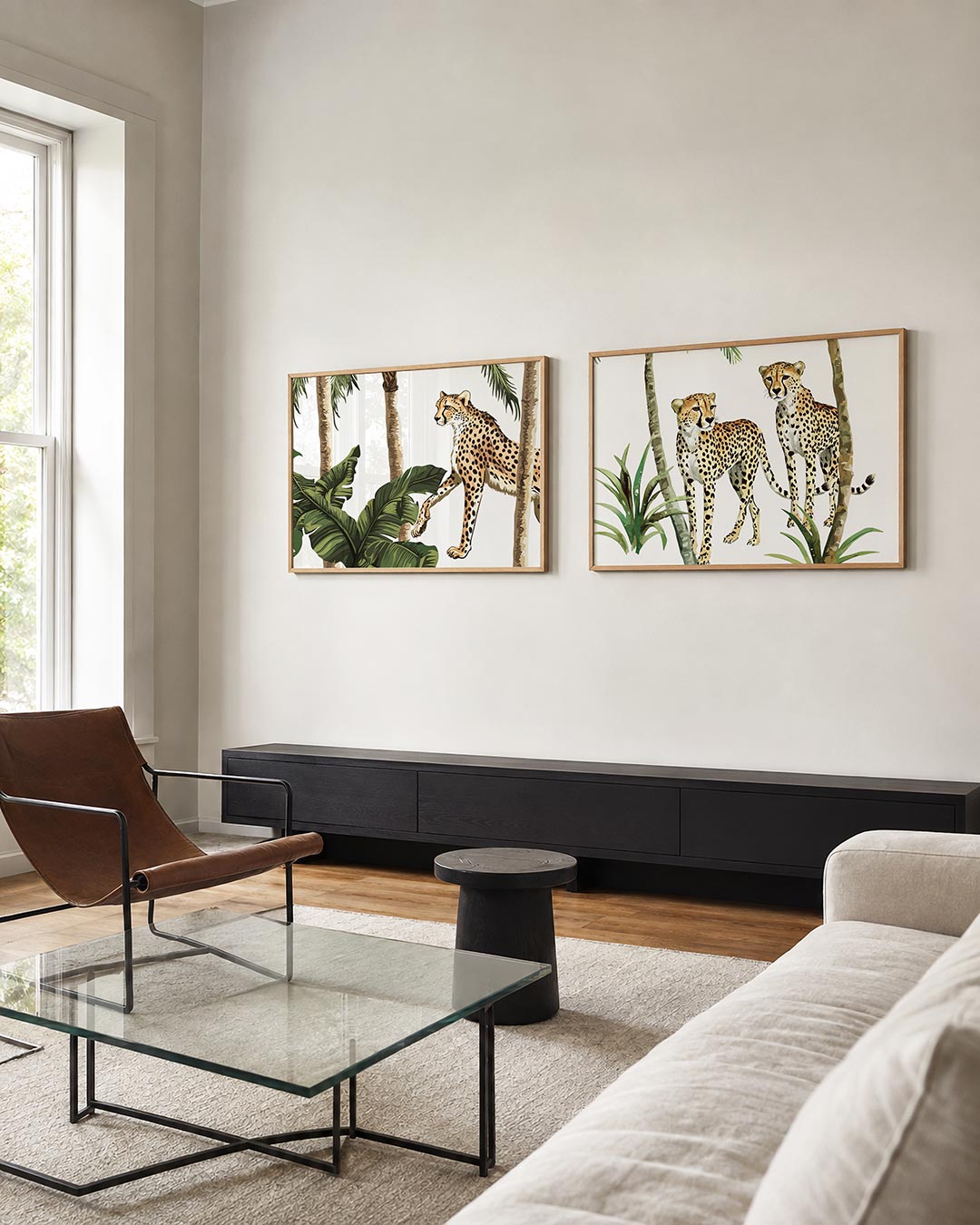 Twee liggende posters met een cheeta tussen groene bladeren en slanke palmbomen, aan de muur in een interieur