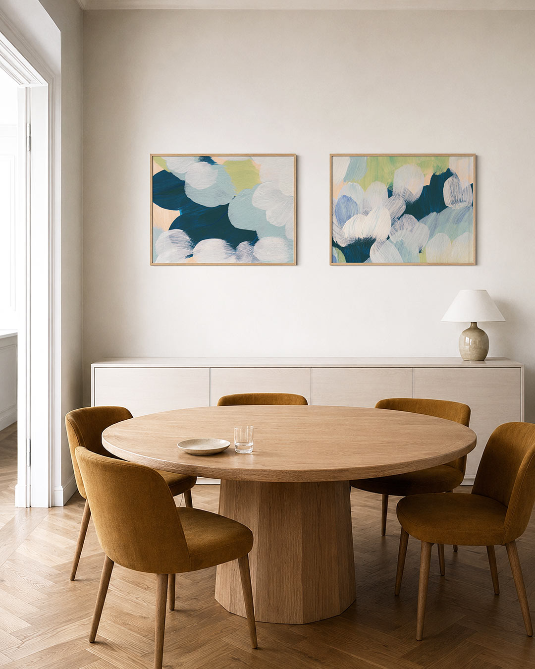 Twee liggende posters met ronde vormen in blauw, wit en groen, aan de muur in een interieur