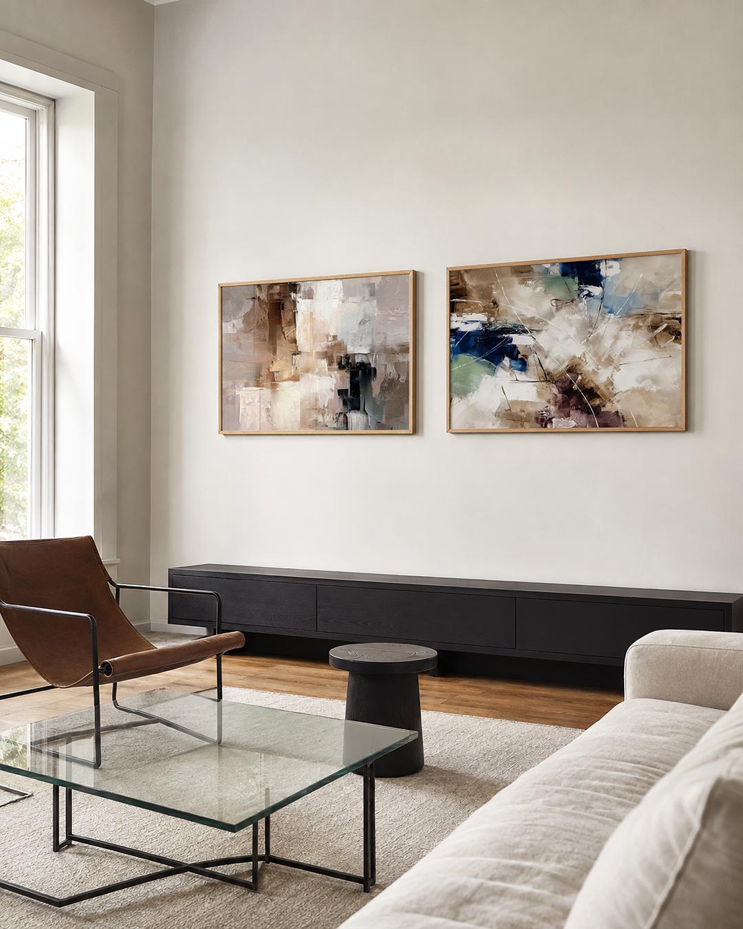 Twee liggende posters met zachte aardetinten met lichte contrasten en kleurvlakken, aan de muur in een interieur