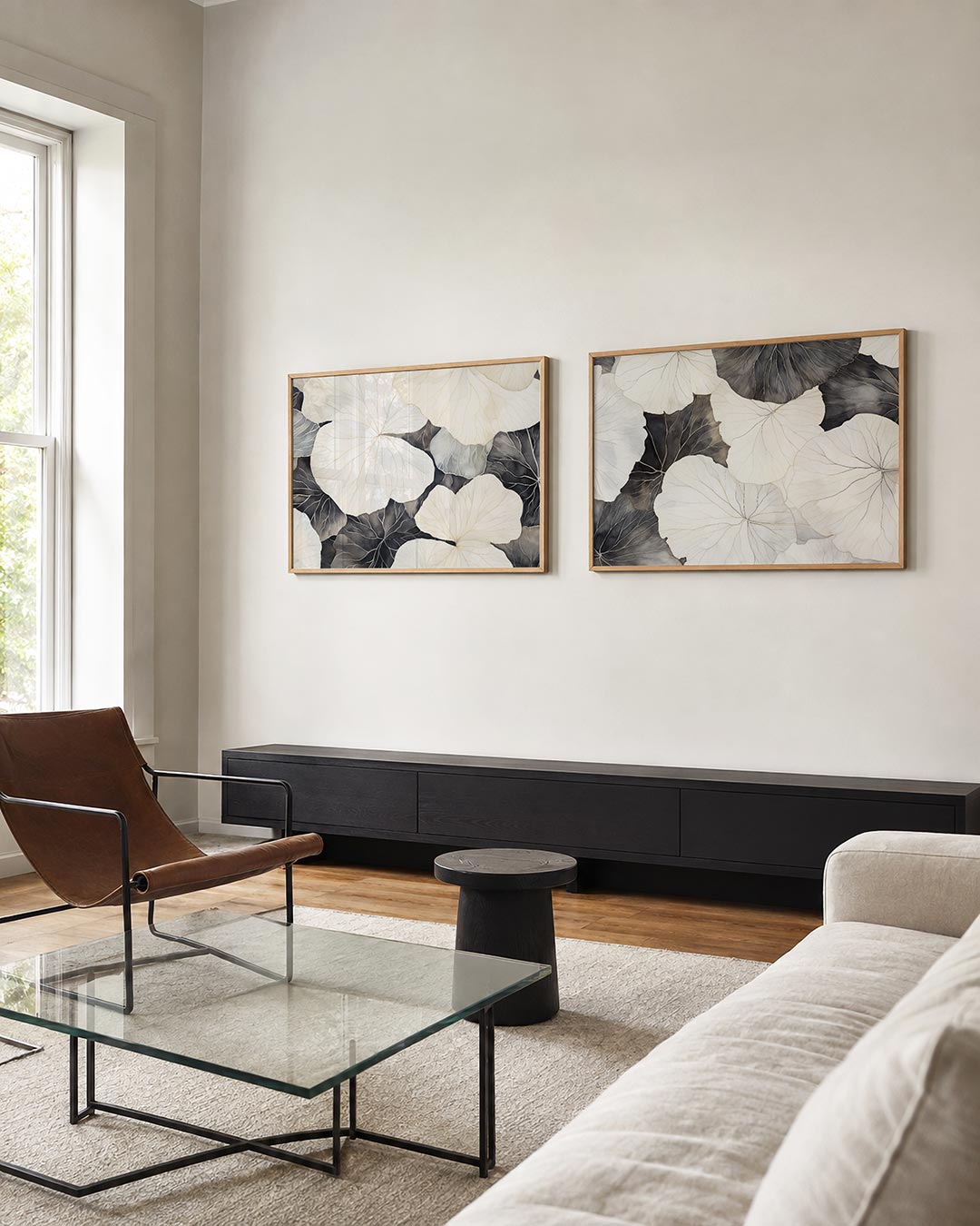 Twee liggende posters met een spel van grote, overlappende bladvormen in zachte wit, aan de muur in een interieur