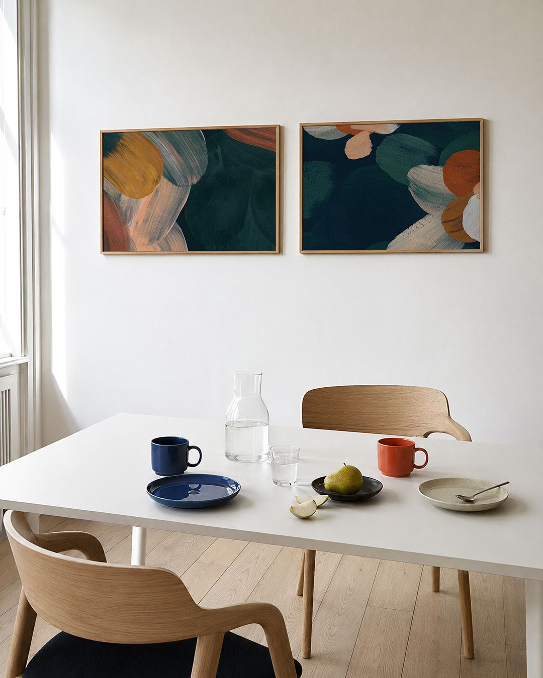 Tweedelige posterset met vloeiende penseelstreken in warme tinten, getoond in een interieur