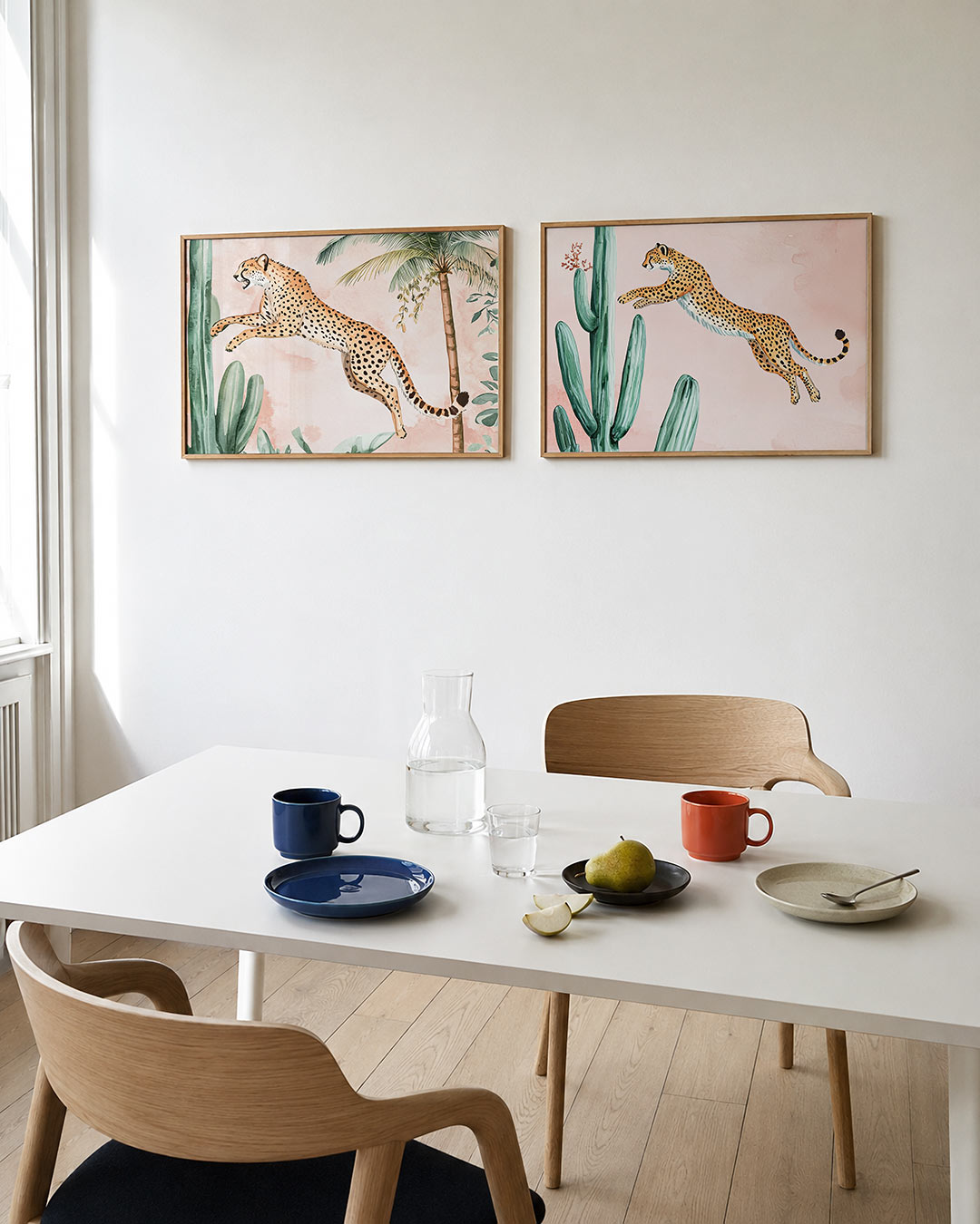 Tweedelige posterset met een sierlijke cheetah springt tussen groene planten en palmbomen, getoond in een interieur