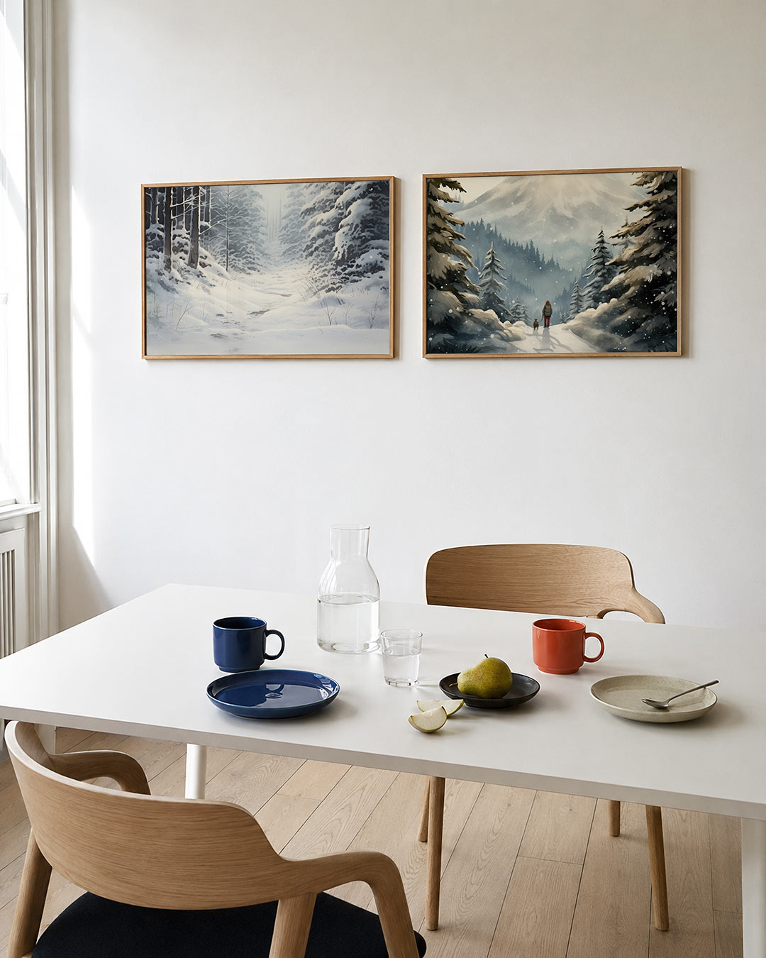 Twee liggende posters met een serene winterse scène met besneeuwde bomen en een zacht, aan de muur in een interieur