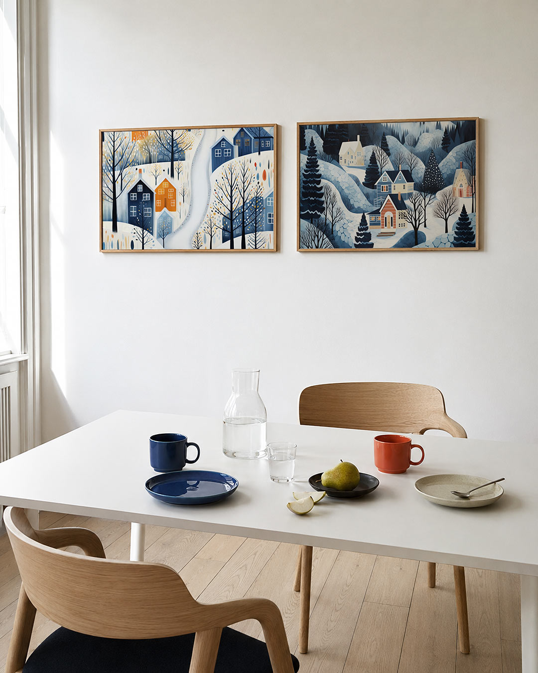 Tweedelige posterset met een charmant dorp in de sneeuw, getoond in een interieur