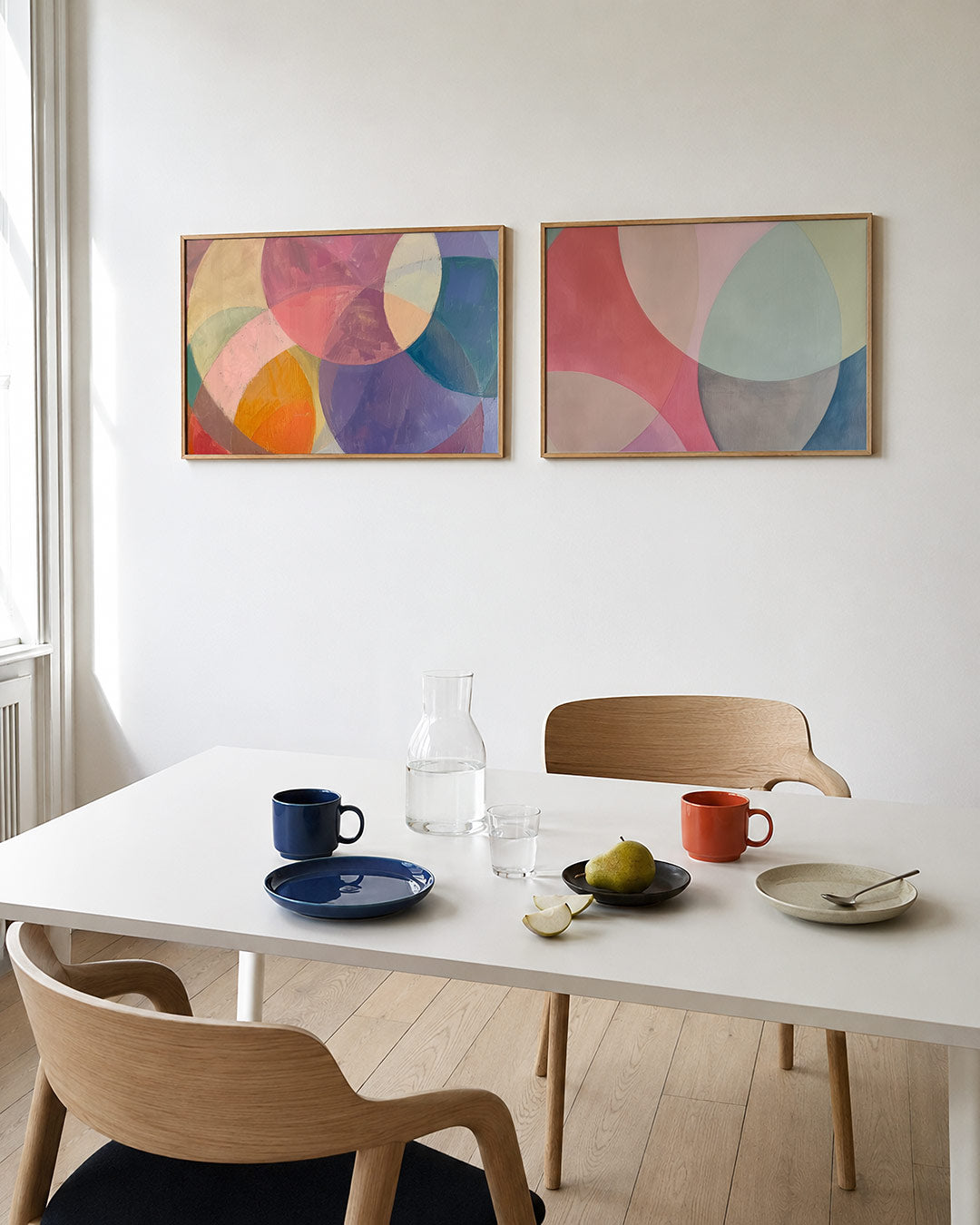 Tweedelige posterset met overlappende cirkels in zachte tinten roze, paars, geel en blauw, getoond in een interieur