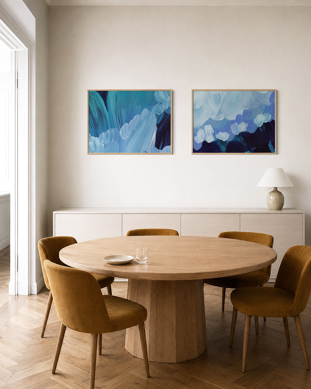 Interieurbeeld met twee liggende posters: vloeiende blauwe penseelstreken die elkaar overlappen