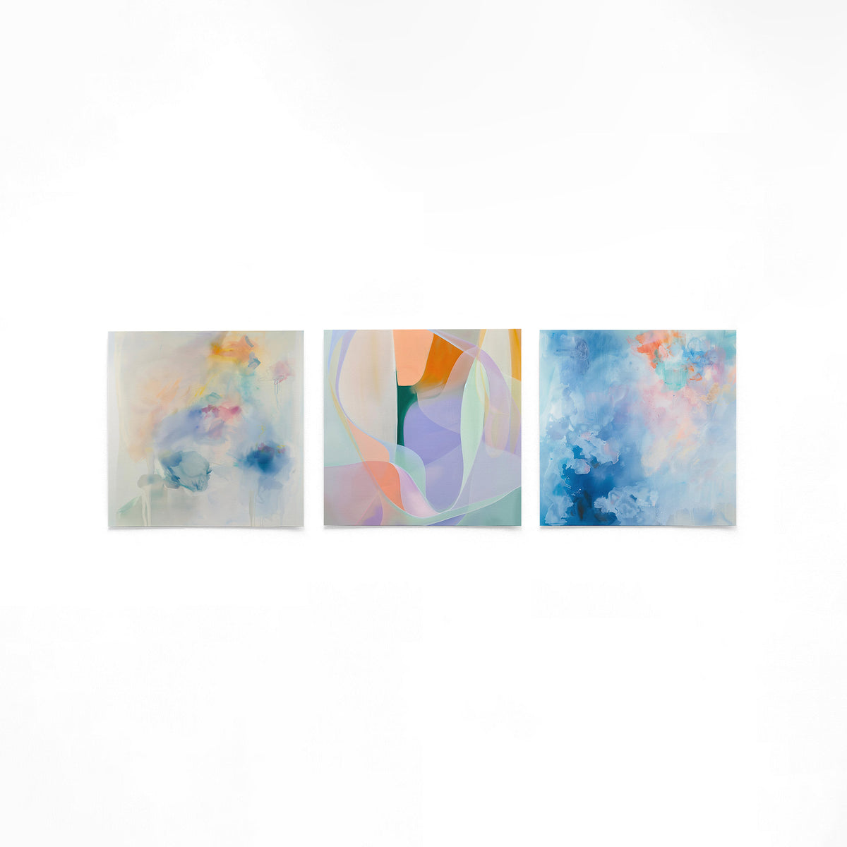 Drie vierkante posters met abstracte kleuren op een gebroken witte achtergrond