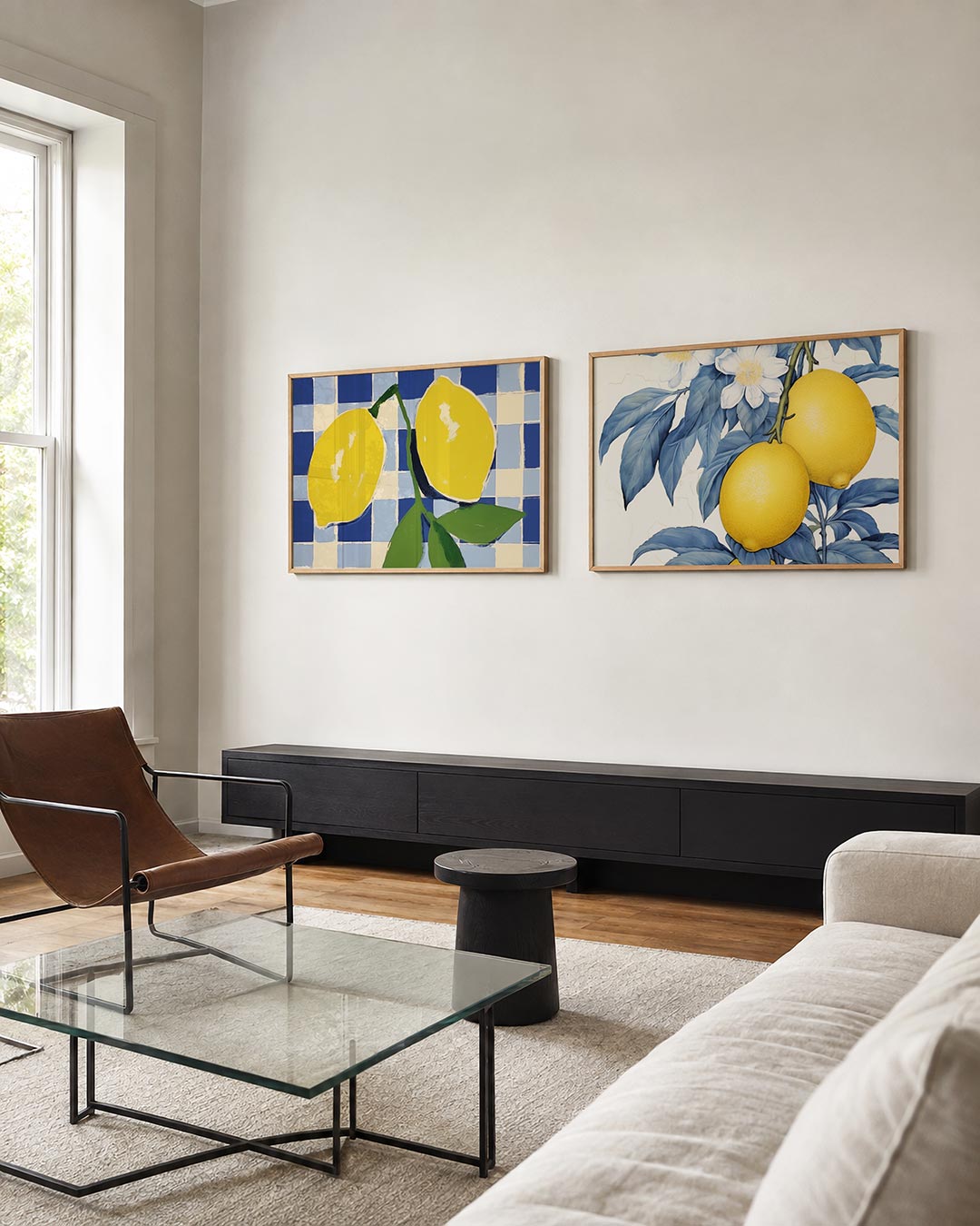 Twee liggende posters met gele citroenen en groene bladeren tegen een blauw-wit tegelpatroon, aan de muur in een interieur