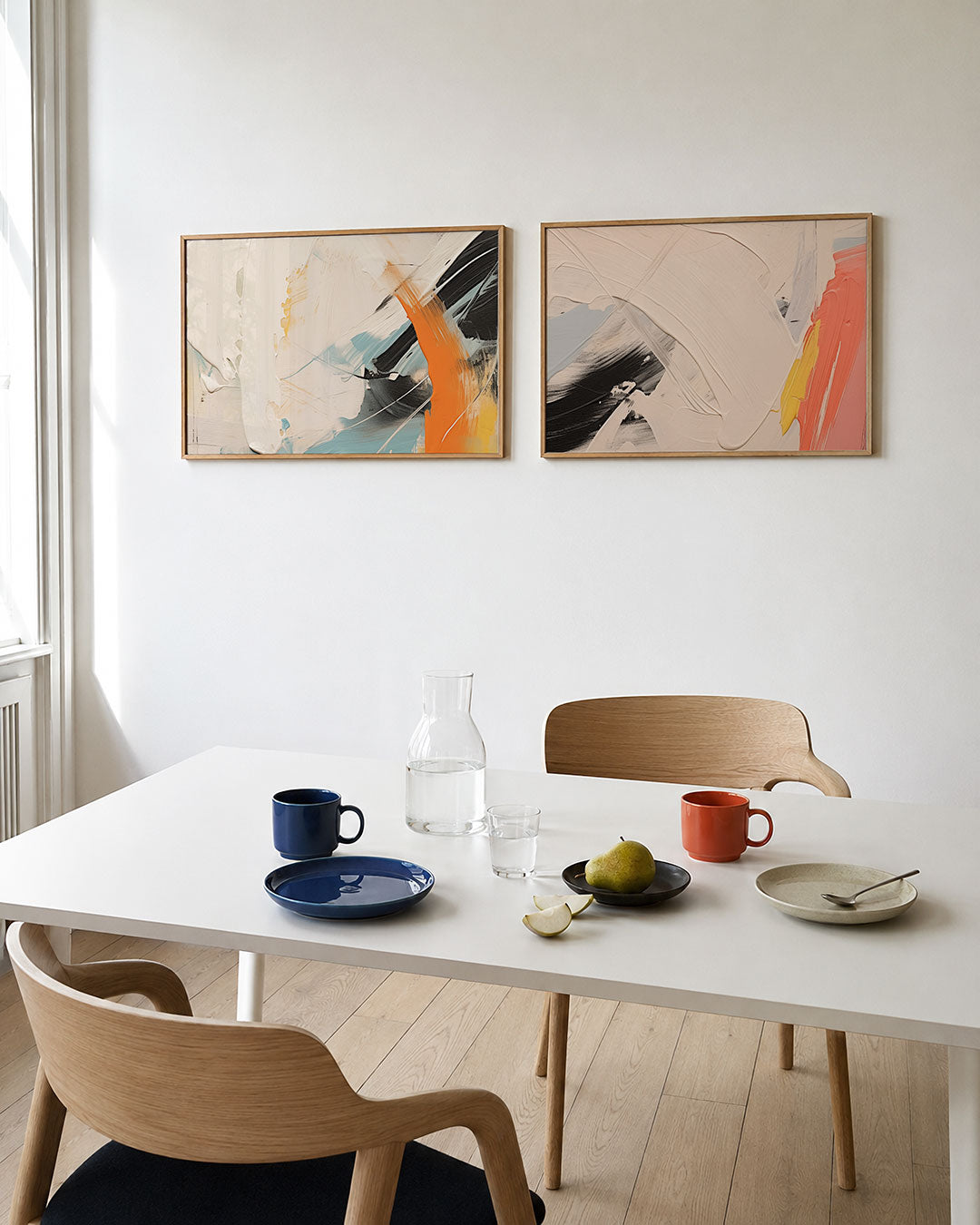 Tweedelige posterset met dikke, vloeiende kleurvlakken in wit, oranje en blauw, getoond in een interieur