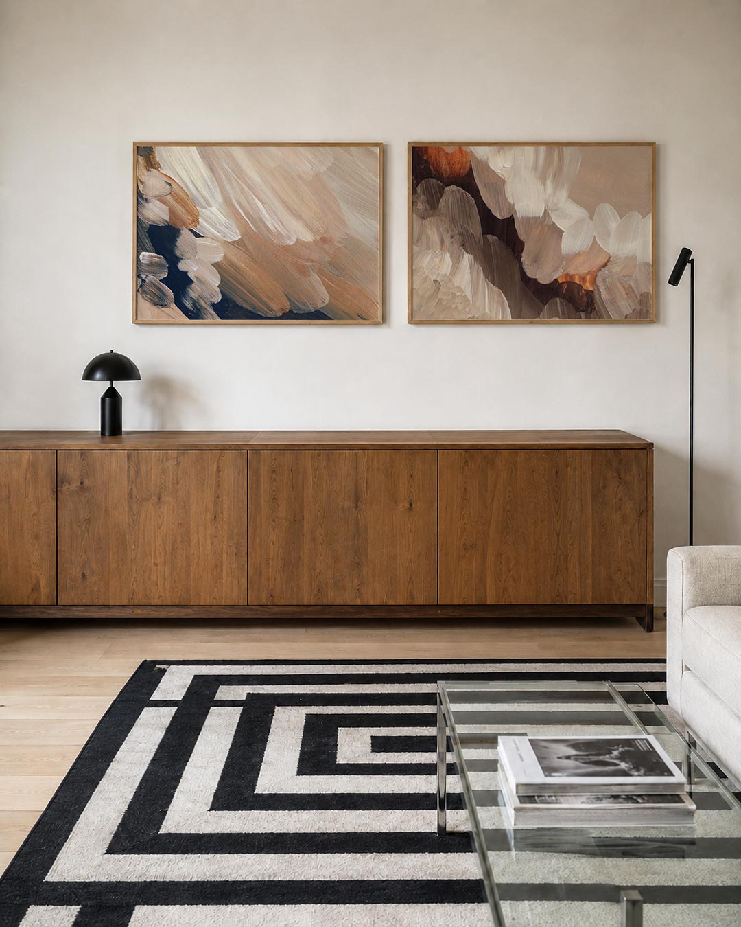 Twee liggende posters met zachte penseelstreken in beige, wit en donkerblauw, aan de muur in een interieur