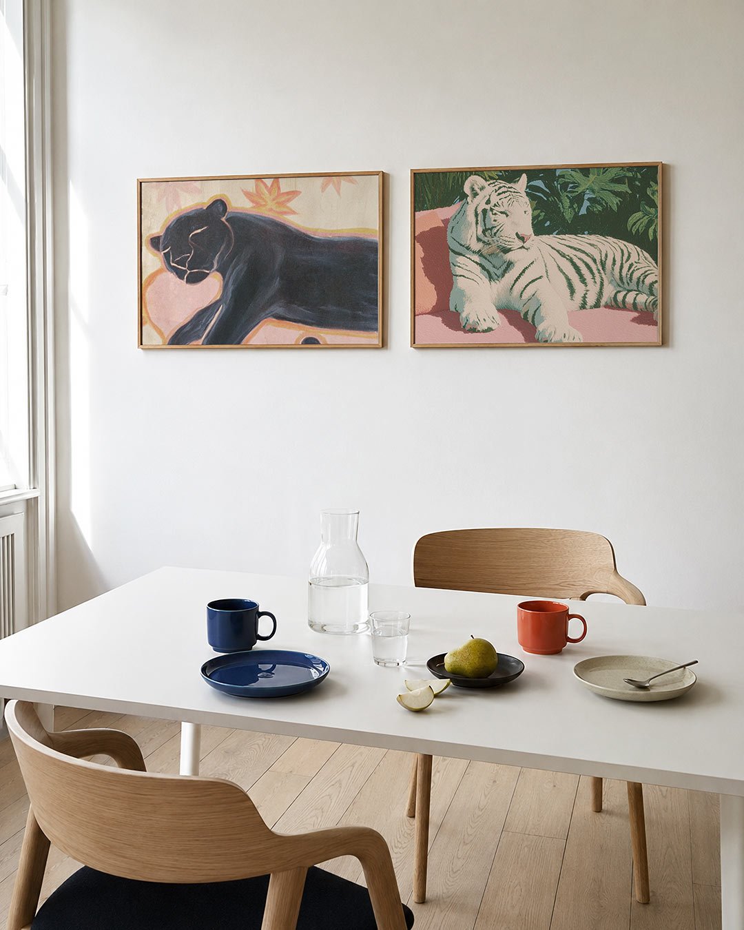 Tweedelige posterset met een zwarte panter op een zachte roze achtergrond, getoond in een interieur