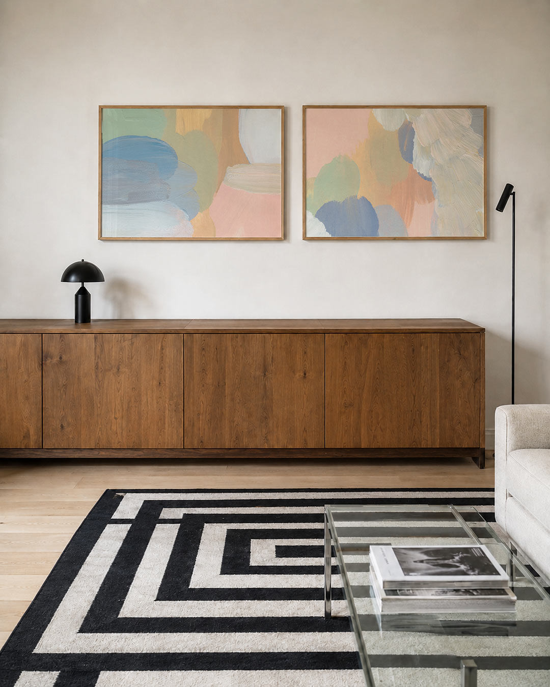 Twee liggende posters met zachte penseelstreken in pastelkleuren, aan de muur in een interieur