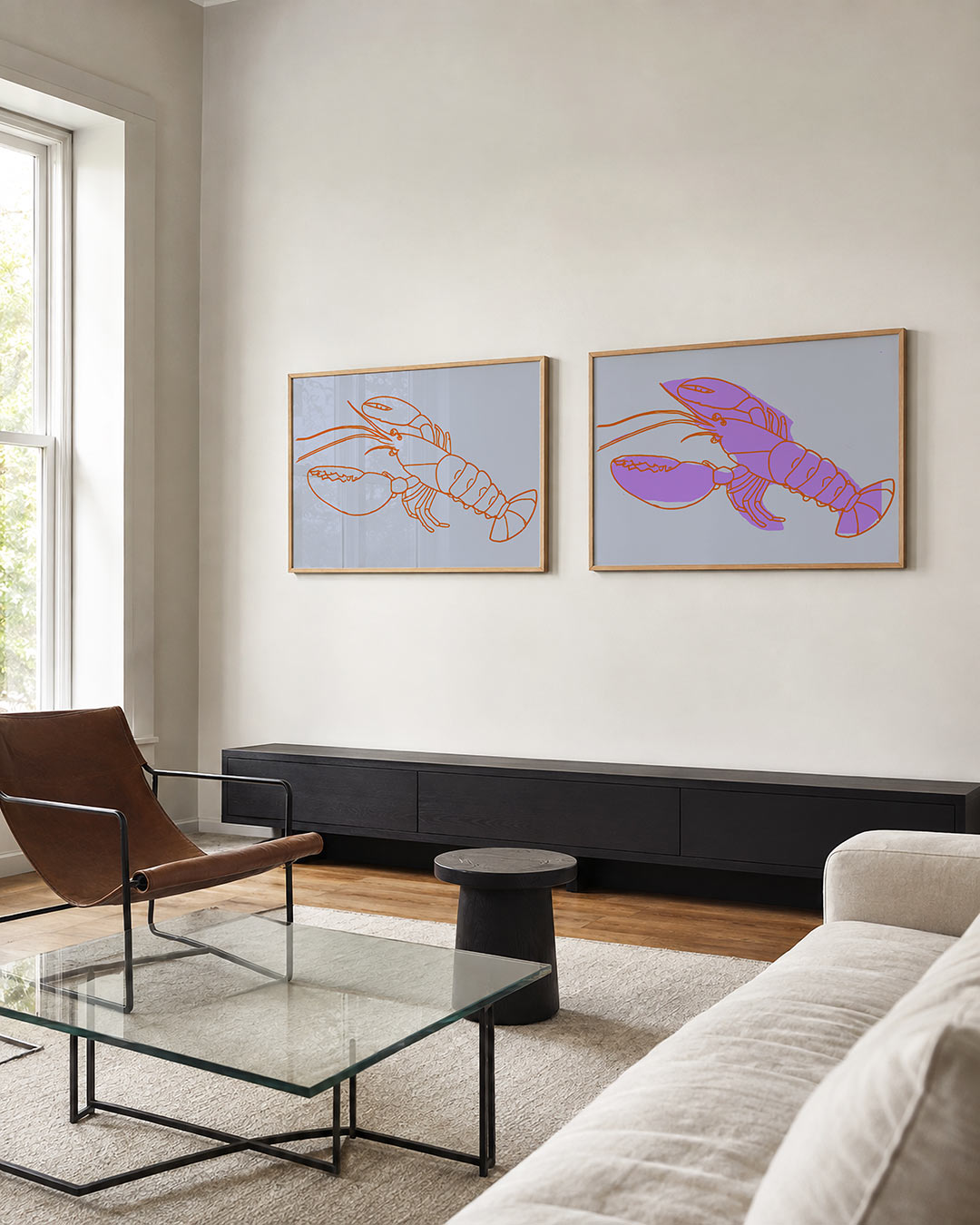 Twee liggende posters met een oranje kreeft met vloeiende lijnen op een zachtblauwe achtergrond, aan de muur in een interieur