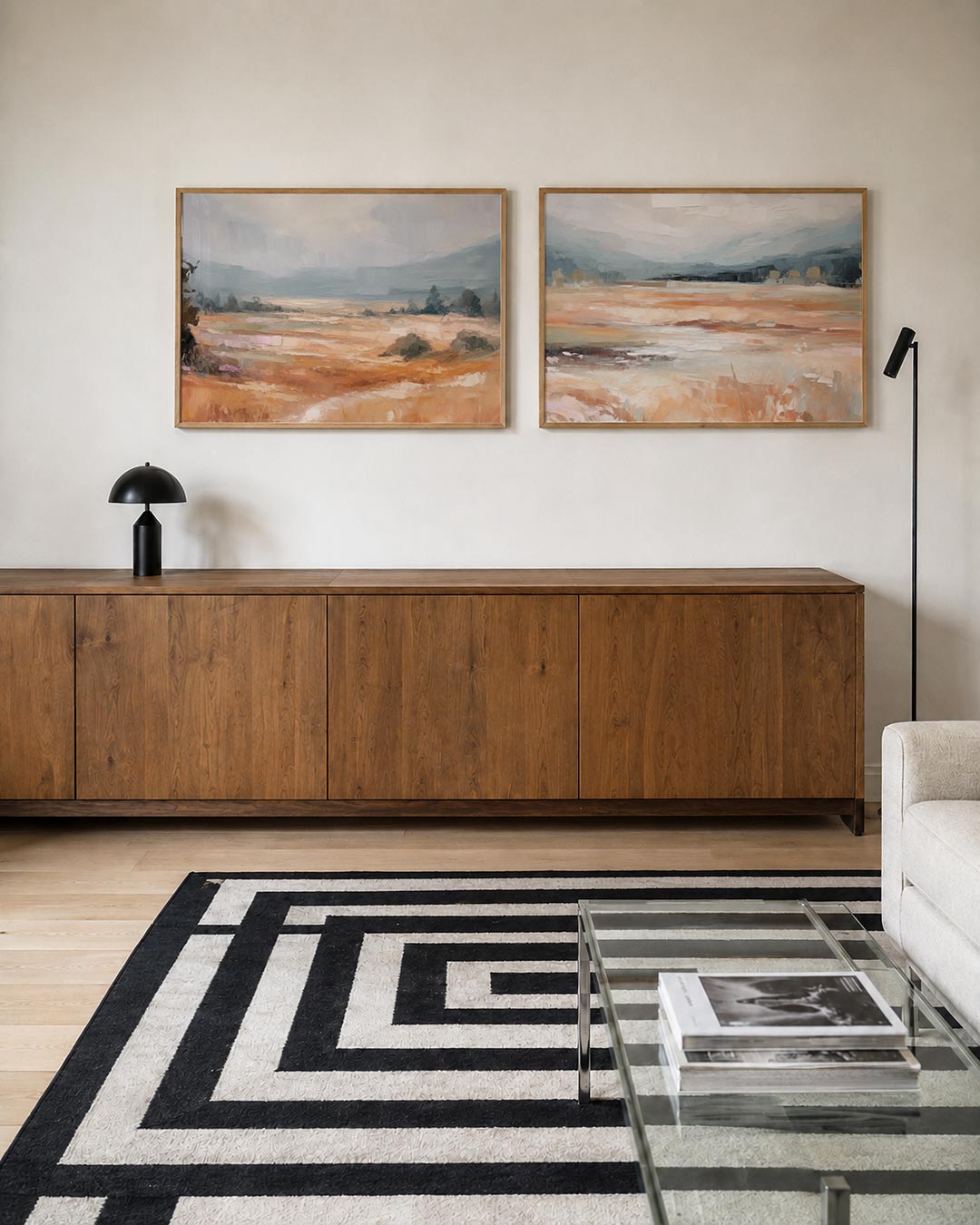 Twee liggende posters met een uitgestrekt landschap met zachte penseelstreken, aan de muur in een interieur