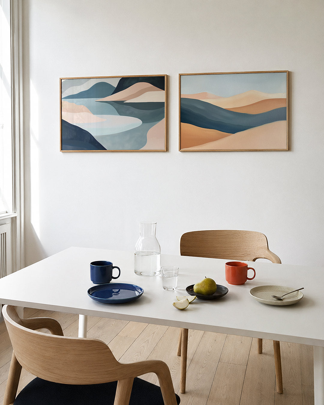 Twee liggende posters met zachte, golvende vormen in pastelkleuren, aan de muur in een interieur
