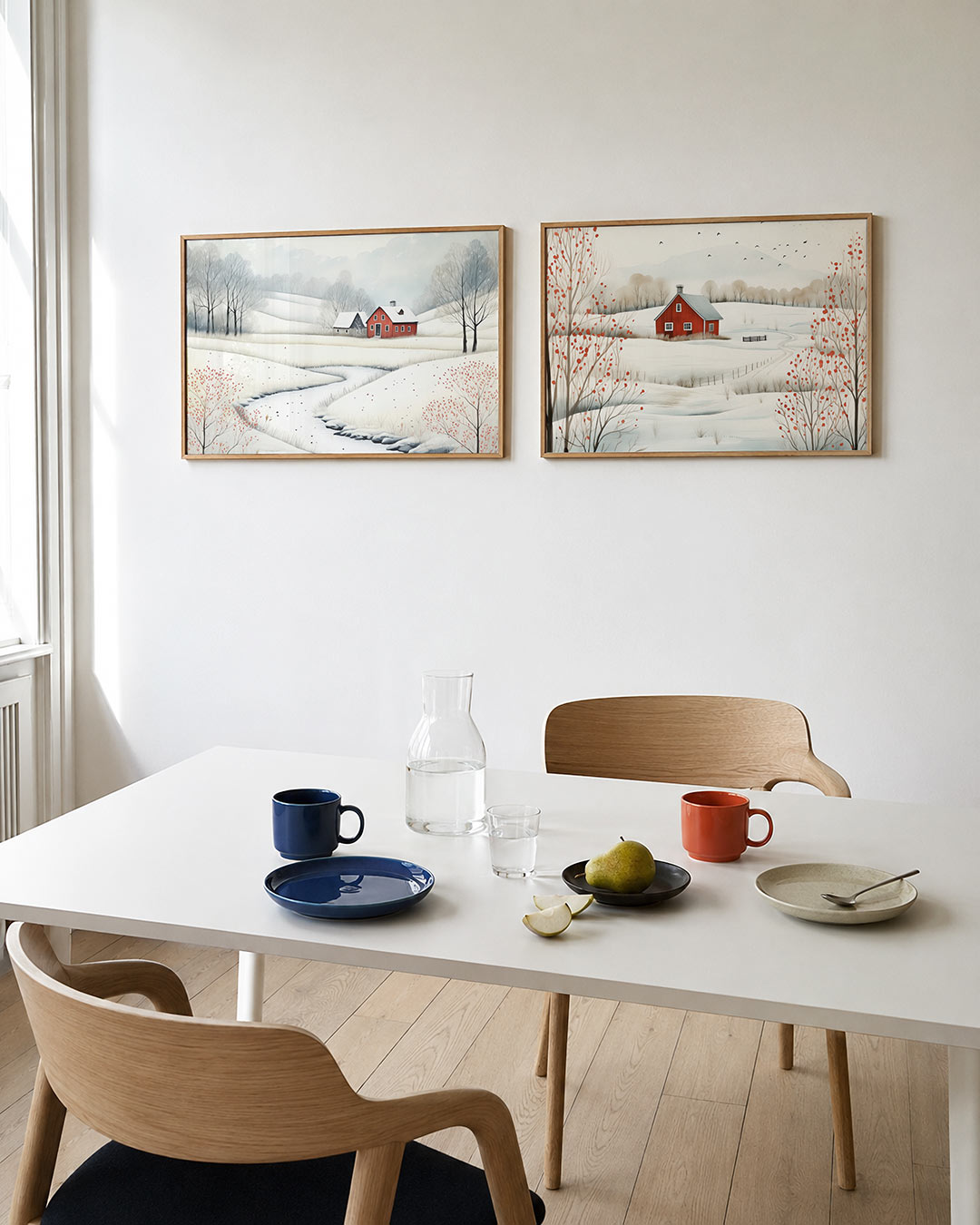 Interieurpresentatie van twee posters met een vredig winterlandschap met een rode boerderij