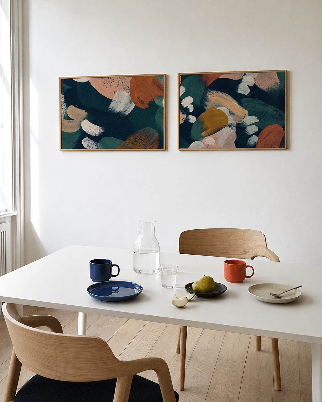 Twee liggende posters met vloeiende penseelstreken, aan de muur in een interieur